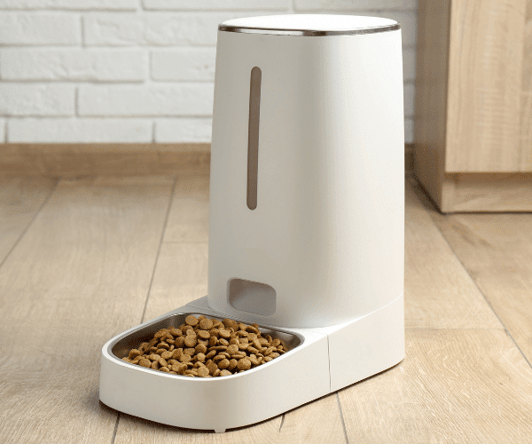 a white smart cat feeder with a bowl of food